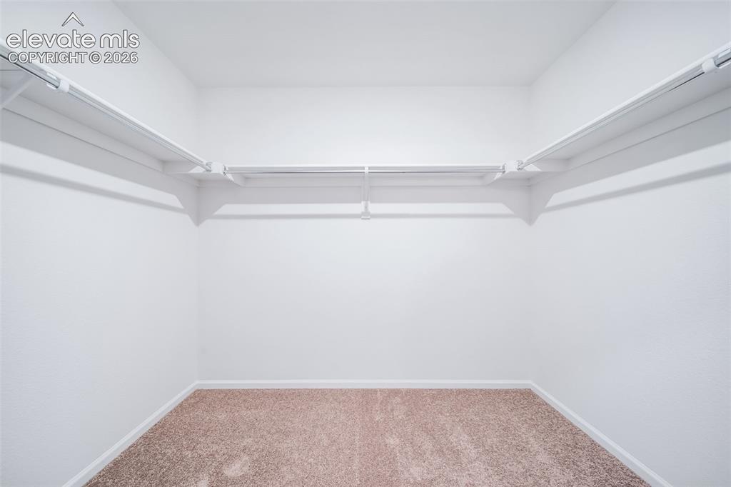 Image 38 of 41: Recessed storage area featuring white shelving, hanging rods, and light-ton