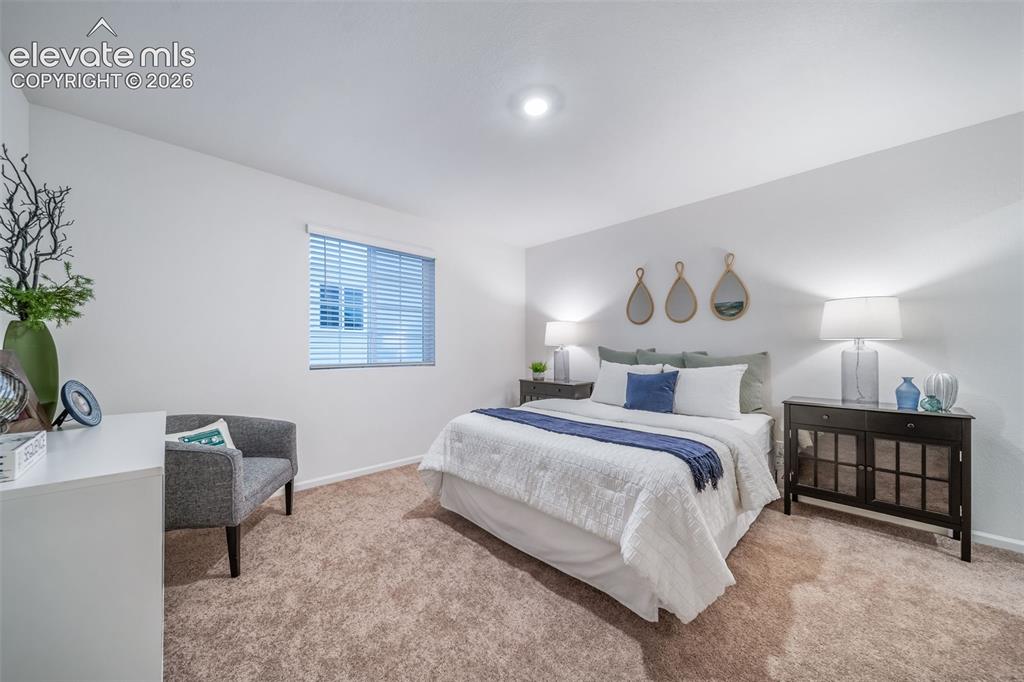 Image 7 of 41: Plush carpeted flooring, window with blinds, recessed ceiling light, and bu