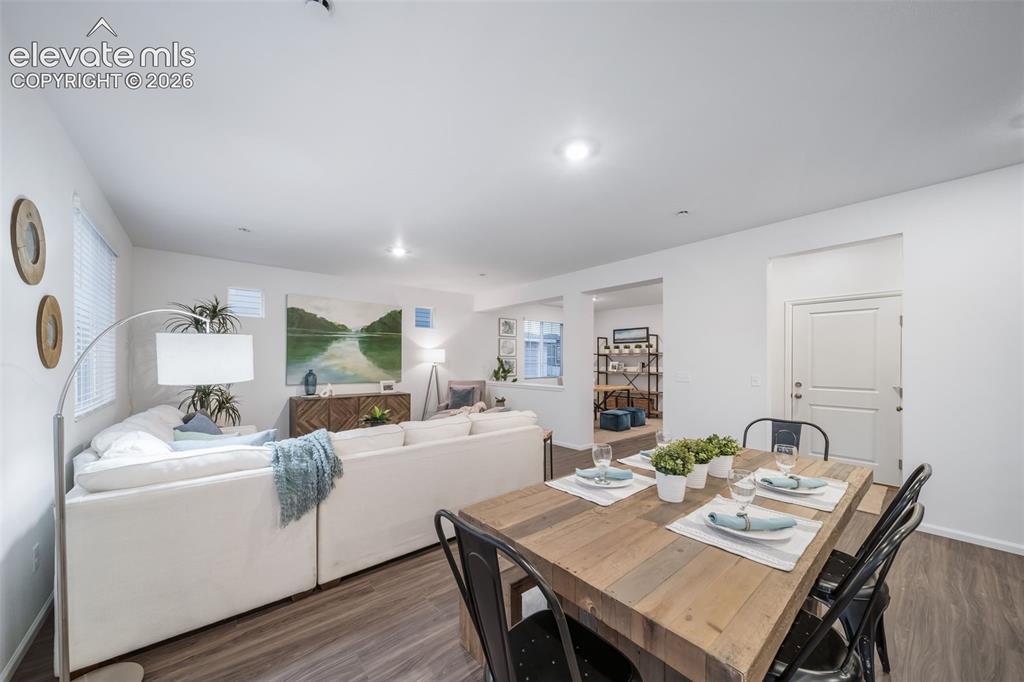 Image 8 of 41: Open-concept living area with wood-finish flooring, recessed lighting, and