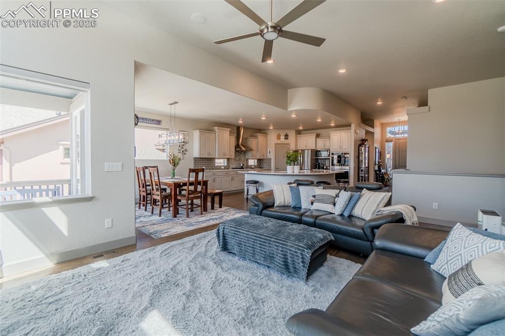Image 13 of 49: Open-concept living area featuring a ceiling fan, recessed lighting, and wo