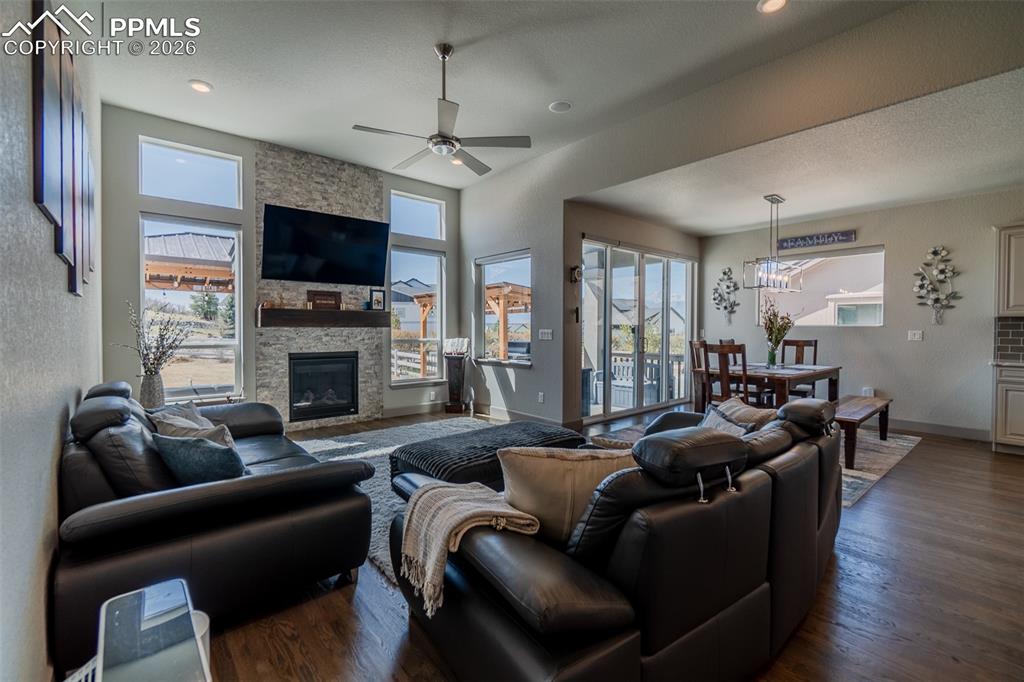 Image 14 of 49: Spacious living area featuring high ceilings, wood-finish flooring, and a s