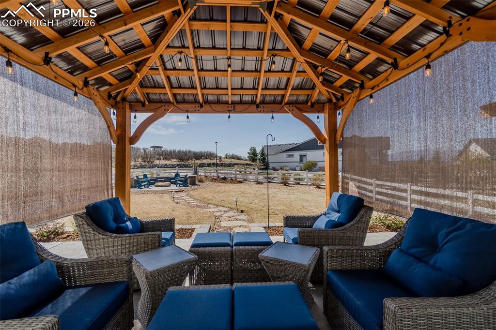 Image 22 of 49: Expansive outdoor gazebo featuring a natural wood frame, a corrugated metal