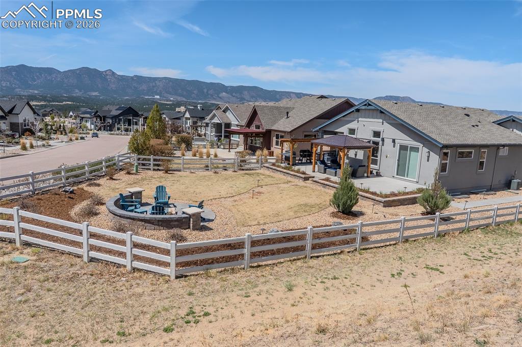 Image 24 of 49: Private backyard featuring a paved patio area with a pergola, a built-in st