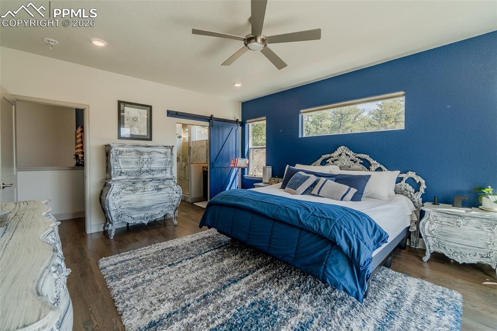 Image 29 of 49: Wood-finish flooring throughout, featuring a blue accent wall with a horizo