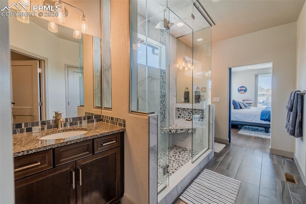 Image 31 of 49: Contemporary bathroom featuring a spacious glass-enclosed shower with a bui