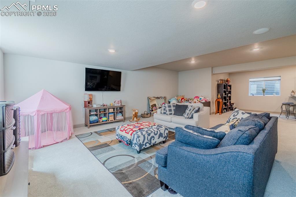 Image 36 of 49: Spacious lower-level area with recessed lighting, light-toned carpeting, an