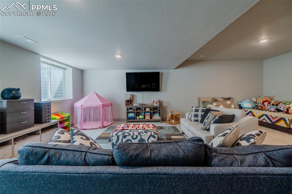 Image 37 of 49: Spacious finished basement with recessed lighting, light-toned walls, and a