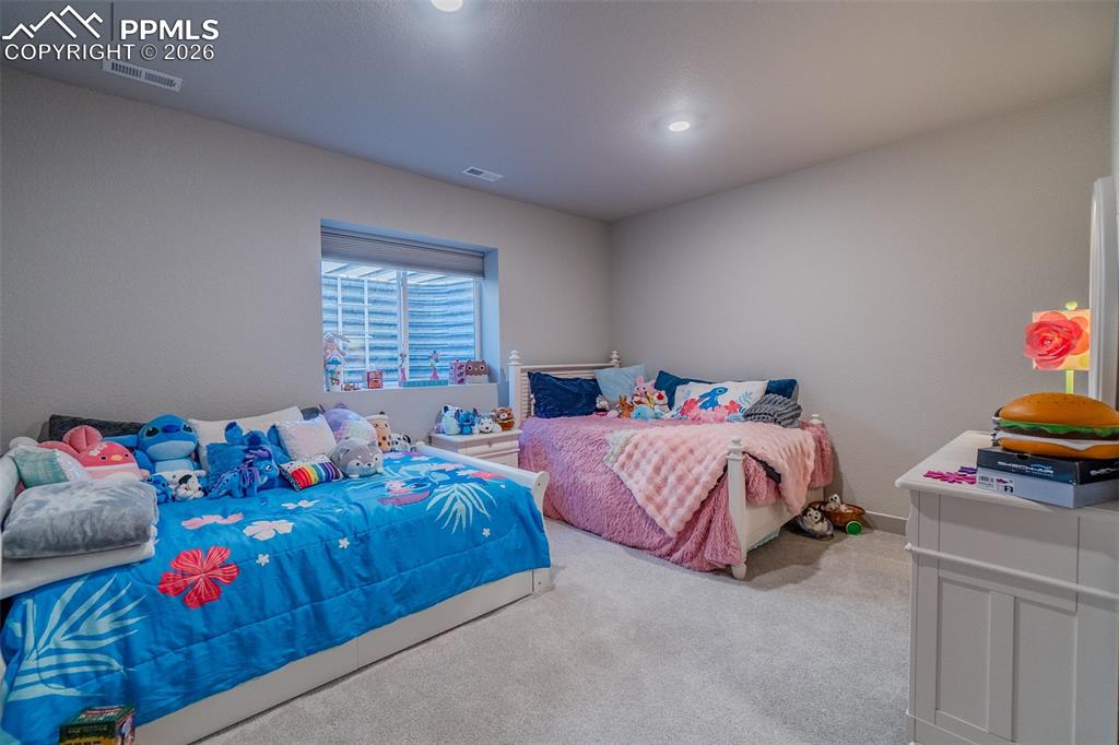 Image 41 of 49: Carpeted room with neutral wall tones and a window well, providing ambient 