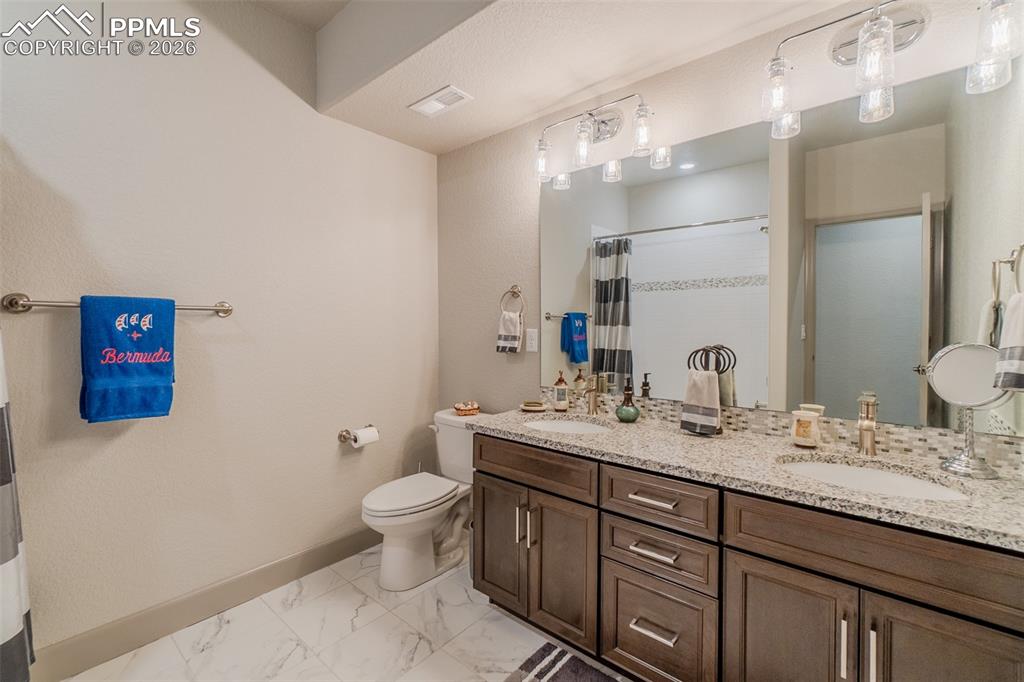 Image 42 of 49: Dual vanity with undermount sinks and light-toned granite countertop