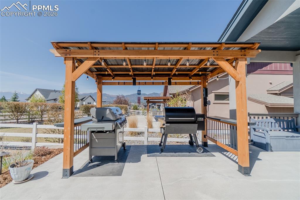Image 44 of 49: Covered outdoor patio area featuring a wooden pergola with a metal roof