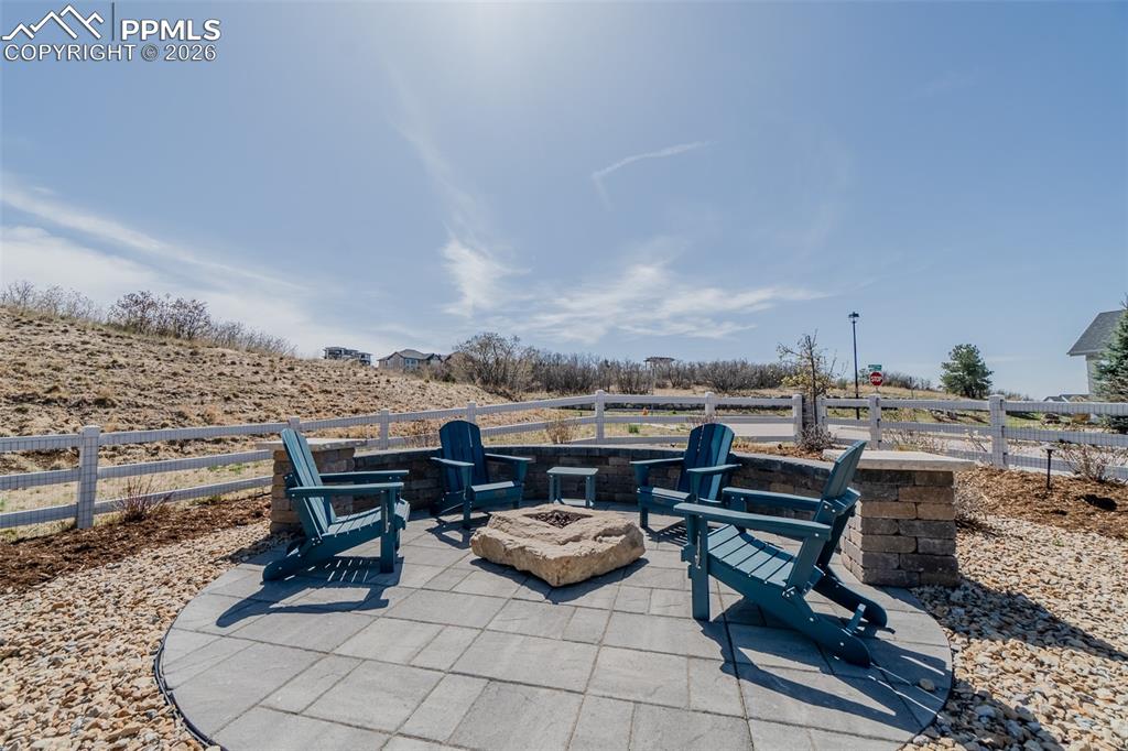 Image 46 of 49: Outdoor patio area featuring a stone block fire pit