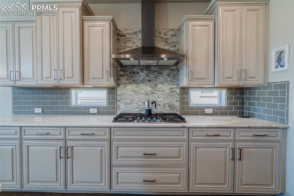 Image 7 of 49: Gourmet kitchen featuring light-toned cabinetry, a built-in gas range, a st
