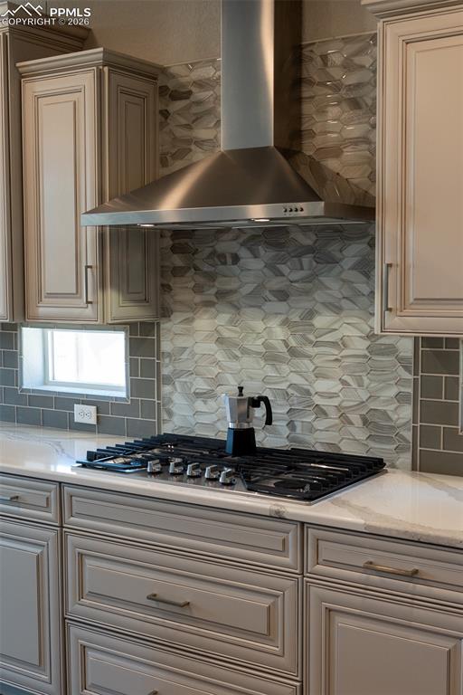 Image 8 of 49: Kitchen featuring a stainless steel range hood, a gas cooktop, light-toned 