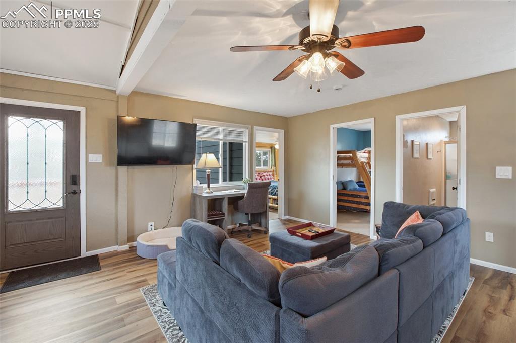 Image 15 of 36: Living area with wood finished floors, plenty of natural light, a ceiling f
