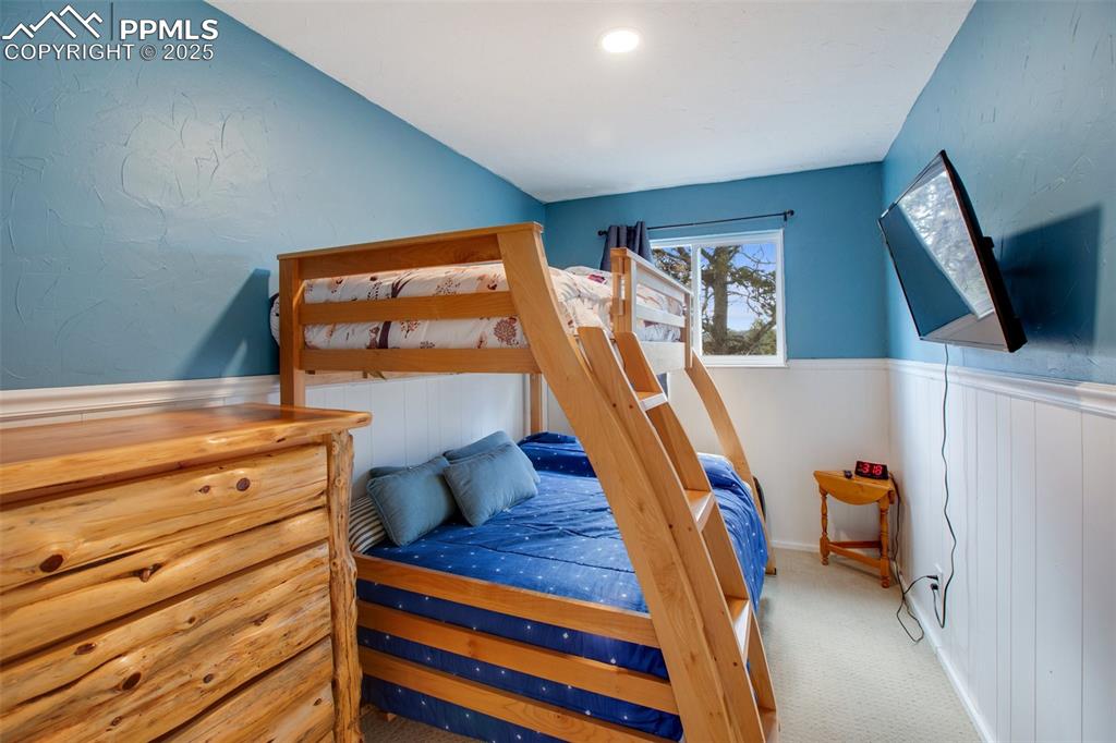 Image 28 of 36: Carpeted bedroom featuring a wainscoted wall and a textured wall