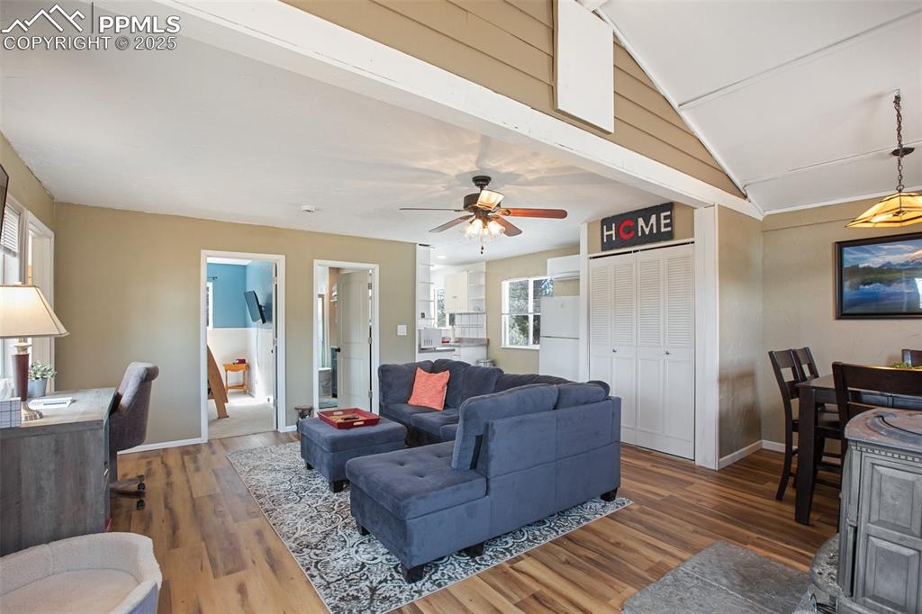 Image 8 of 36: Living area featuring lofted ceiling, wood finished floors, and ceiling fan