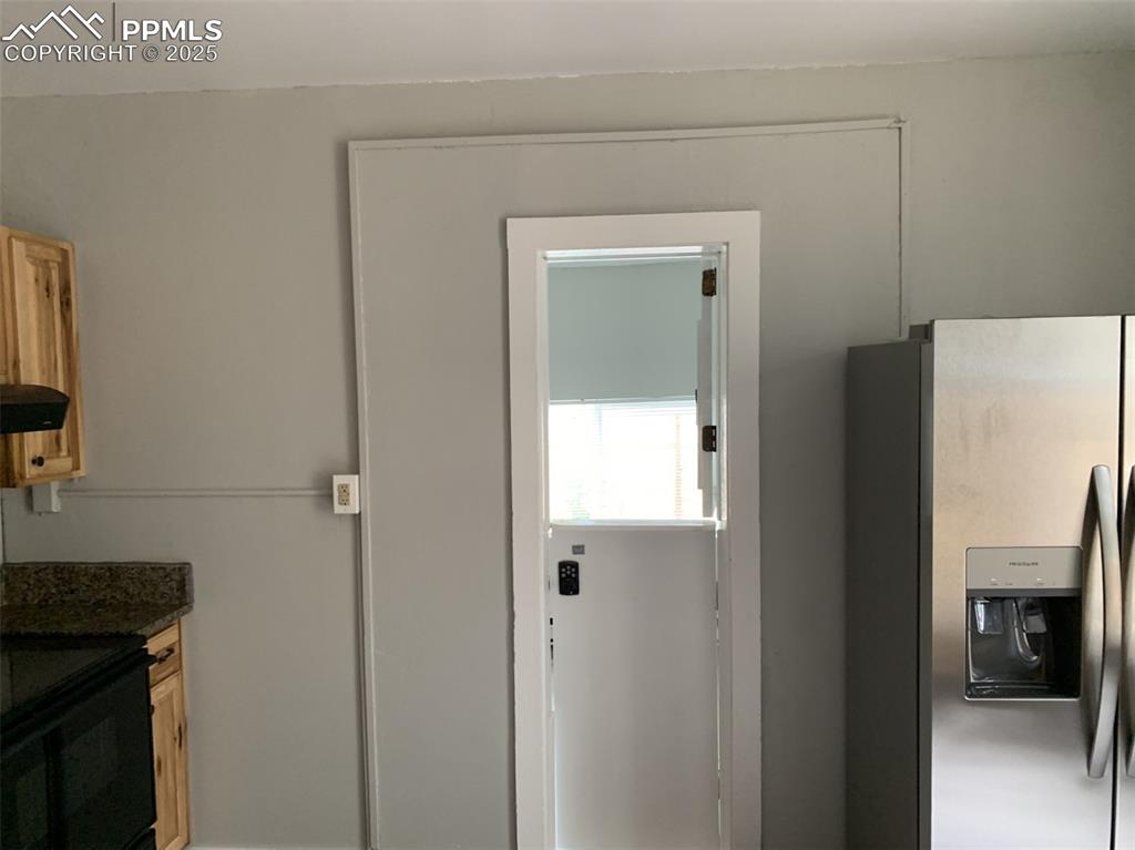 Image 12 of 49: Kitchen with stainless steel fridge with ice dispenser, range with electric