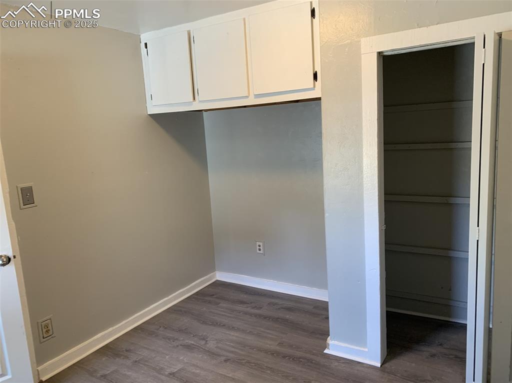 Image 19 of 49: Washroom featuring dark wood-style floors and baseboards
