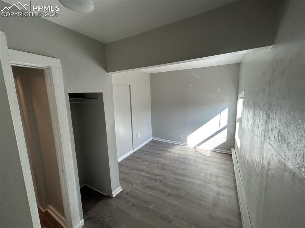 Image 32 of 49: Unfurnished bedroom featuring dark wood-style floors and baseboards