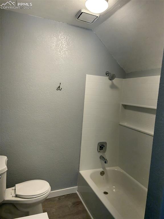 Image 42 of 49: Bathroom featuring vaulted ceiling, wood finished floors, shower / bathtub