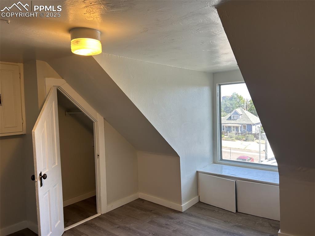 Image 45 of 49: Additional living space featuring a textured ceiling, dark wood finished fl