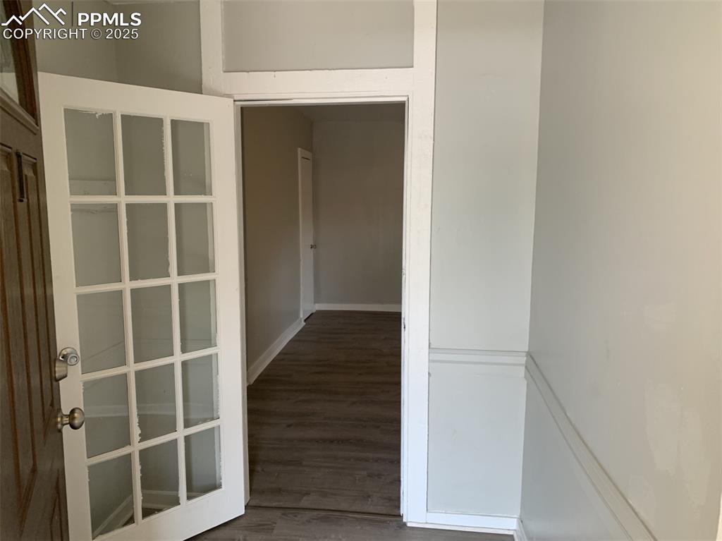 Image 8 of 49: Entrance APT 1 room with wood finished floors and baseboard heating