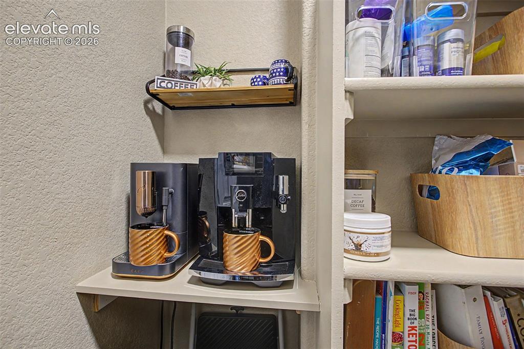 Image 10 of 35: Built-in shelving unit featuring a dedicated counter space, an upper wall-m