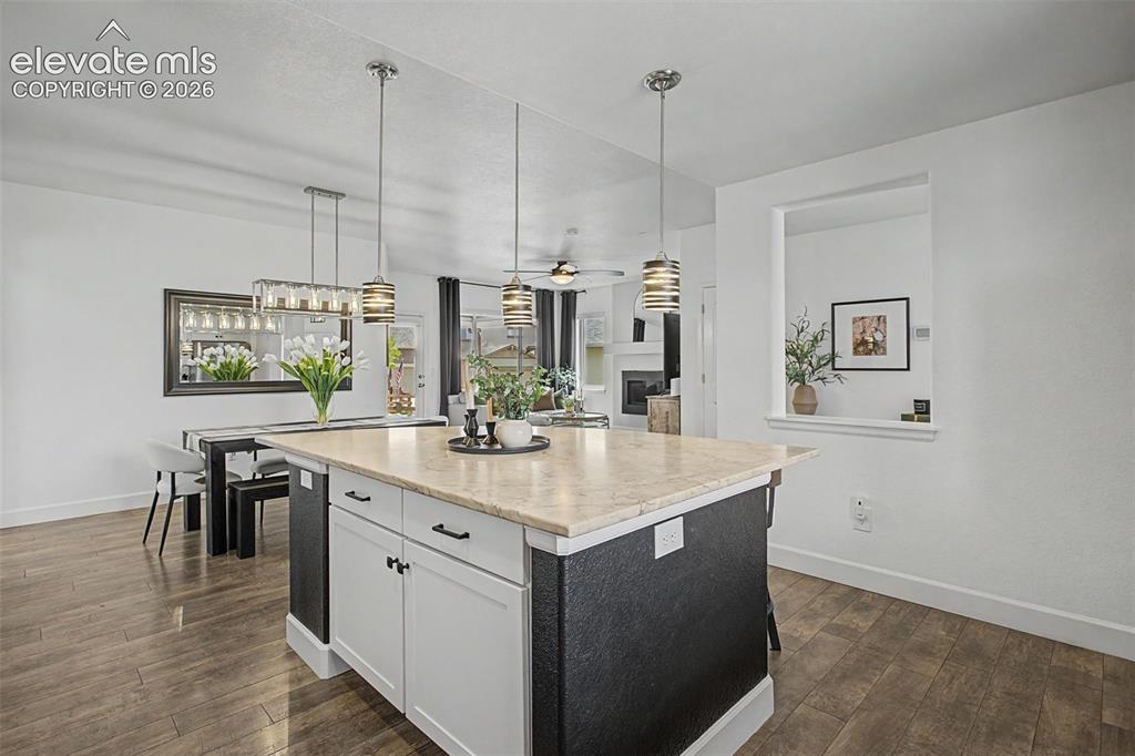 Image 11 of 35: Kitchen island featuring a light-toned countertop, white cabinetry with bla