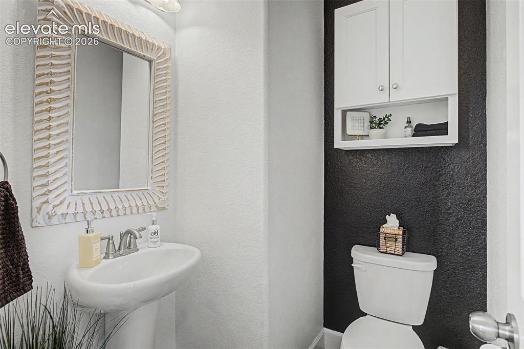 Image 17 of 35: Pedestal sink with brushed nickel faucet, framed mirror, white wall-mounted