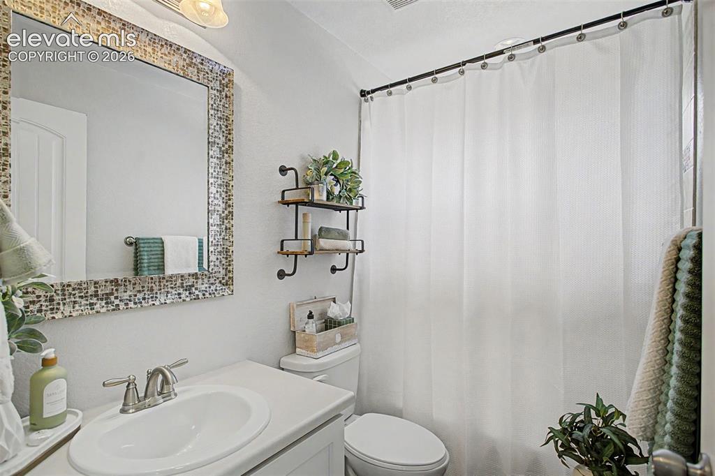 Image 24 of 35: Full bathroom featuring a rectangular mosaic-framed mirror, a single vanity