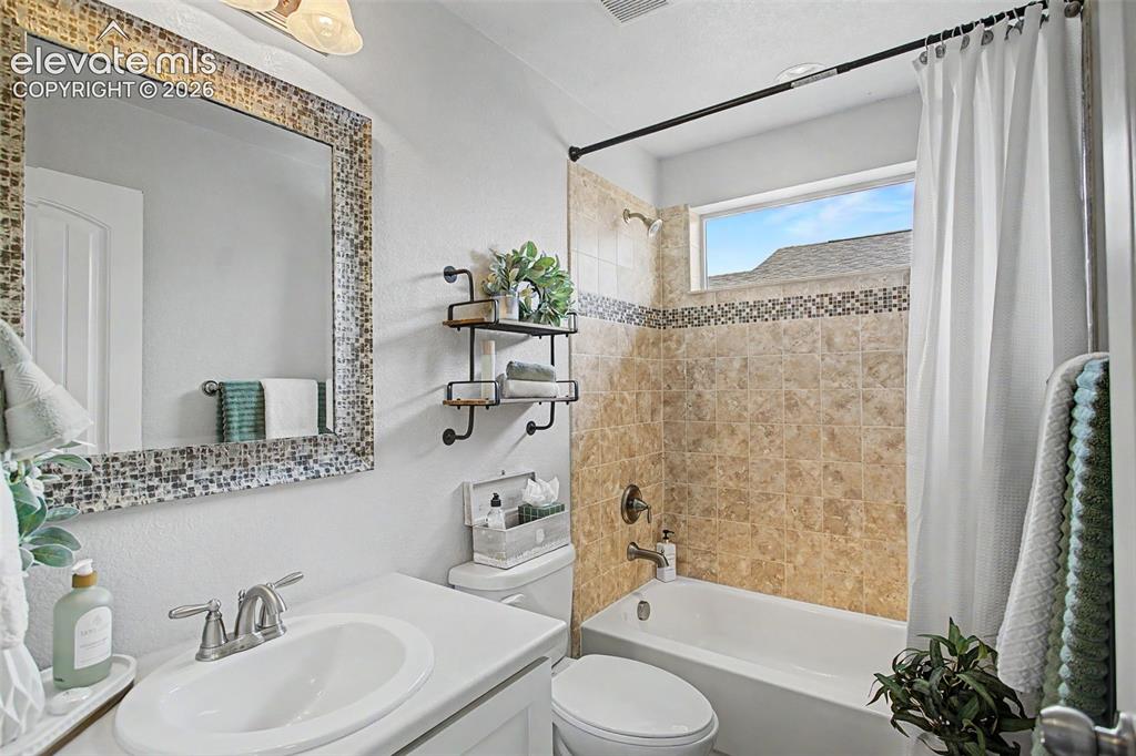 Image 25 of 35: Bathroom featuring a vanity with an integrated sink and brushed nickel fauc