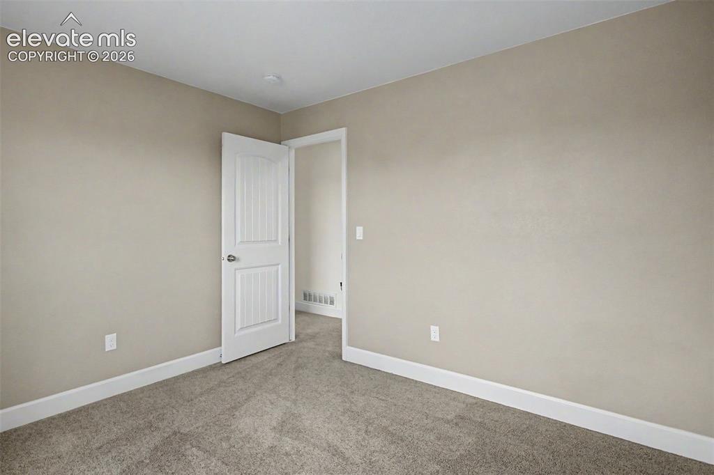 Image 27 of 35: Carpeted interior room featuring light neutral wall tones, white baseboards