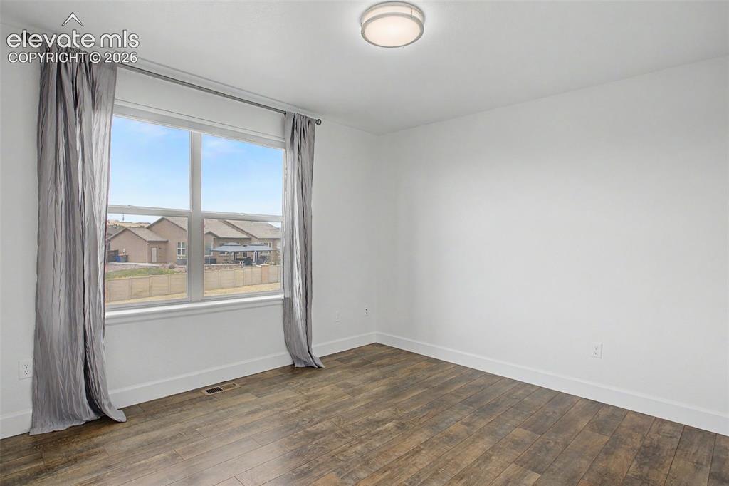 Image 28 of 35: Bright interior space featuring wood-finish flooring, white baseboards, and