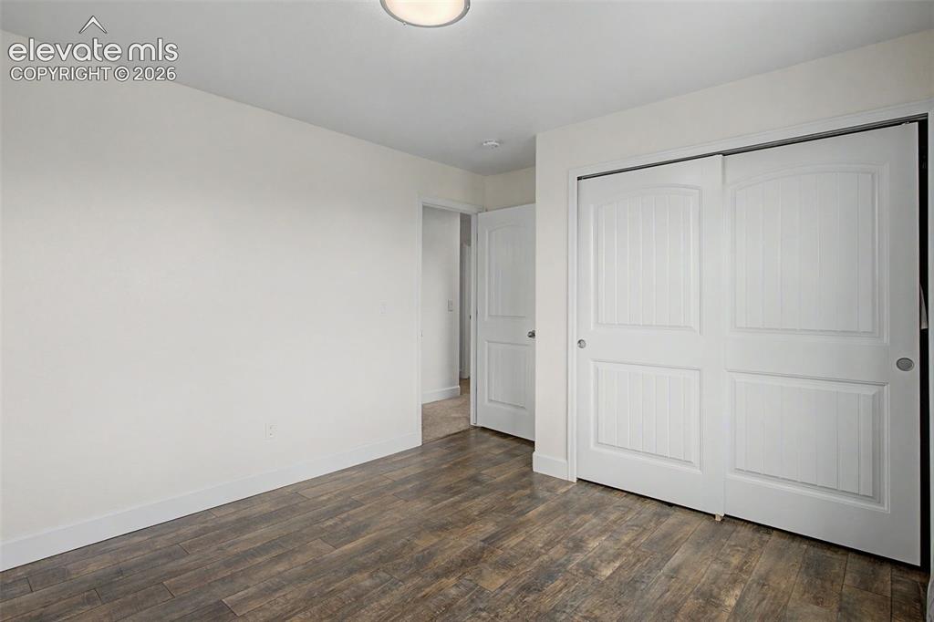 Image 29 of 35: Room featuring wood-finish flooring, white baseboards, and a flush-mount ce