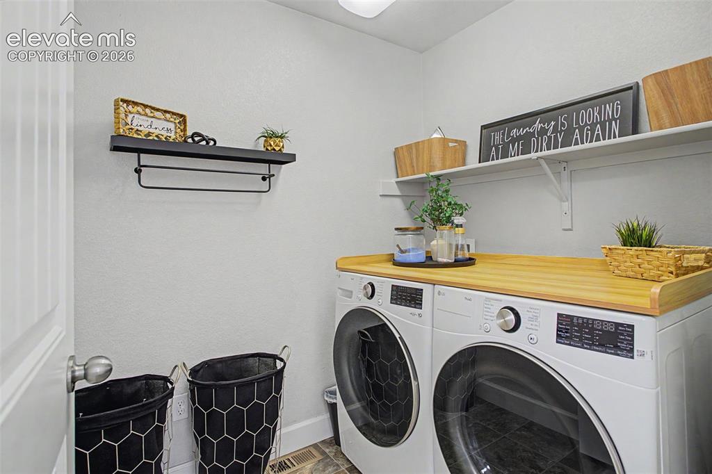 Image 30 of 35: Dedicated utility space featuring a wood-finish countertop, and wall-mounte