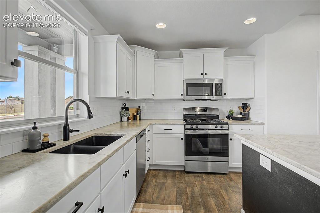 Image 8 of 35: Modern kitchen featuring white shaker cabinetry, stainless steel appliances