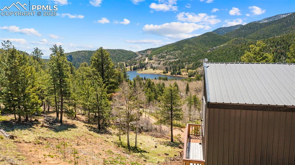 Image 10 of 35: View of mountain backdrop featuring a nearby body of water and a heavily wo