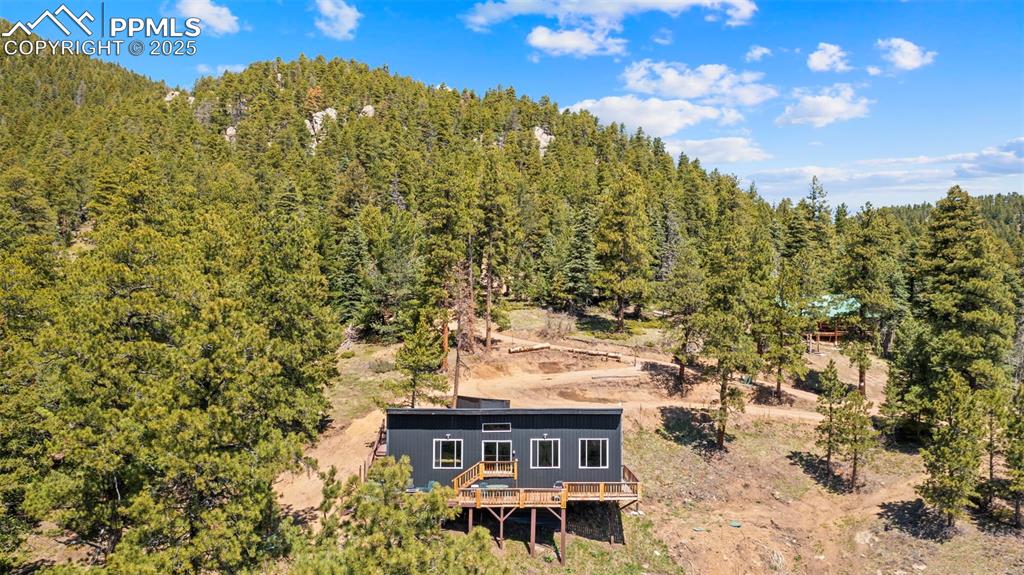 Image 12 of 35: View from above of property with a forest