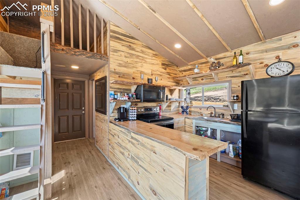 Image 2 of 35: Kitchen with freestanding refrigerator, stainless steel electric range, a s