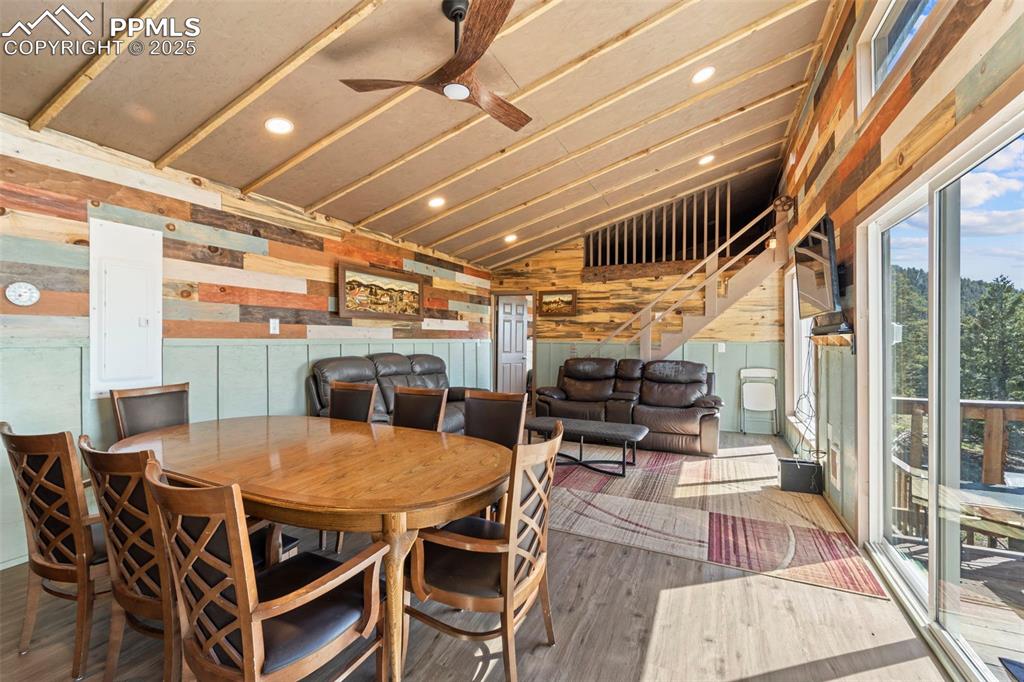 Image 21 of 35: Dining room featuring lofted ceiling, stairs, wood finished floors, wooden 