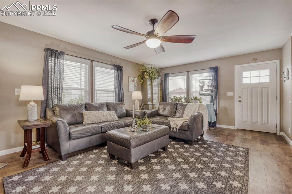 Image 5 of 33: Living area featuring wood-finish flooring, a ceiling fan with integrated l