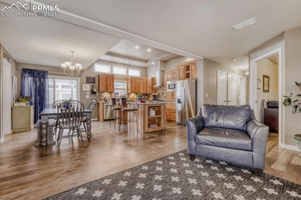 Image 7 of 33: Expansive open-concept space featuring wood-finish flooring, a vaulted ceil