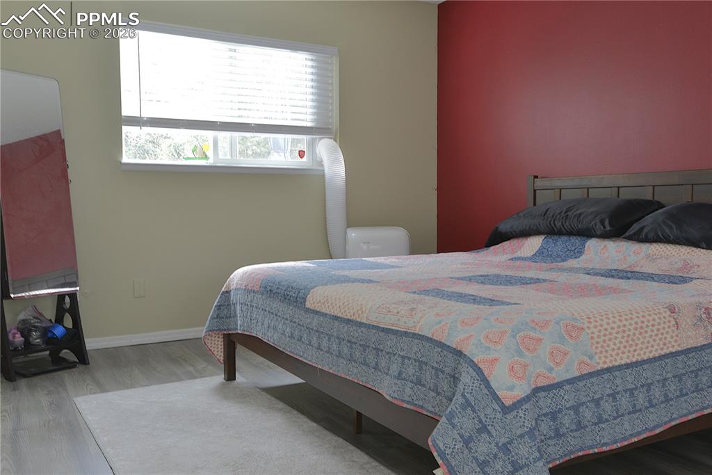 Image 12 of 25: Primary bedroom is on the back of the home, overlooking a private treed lot