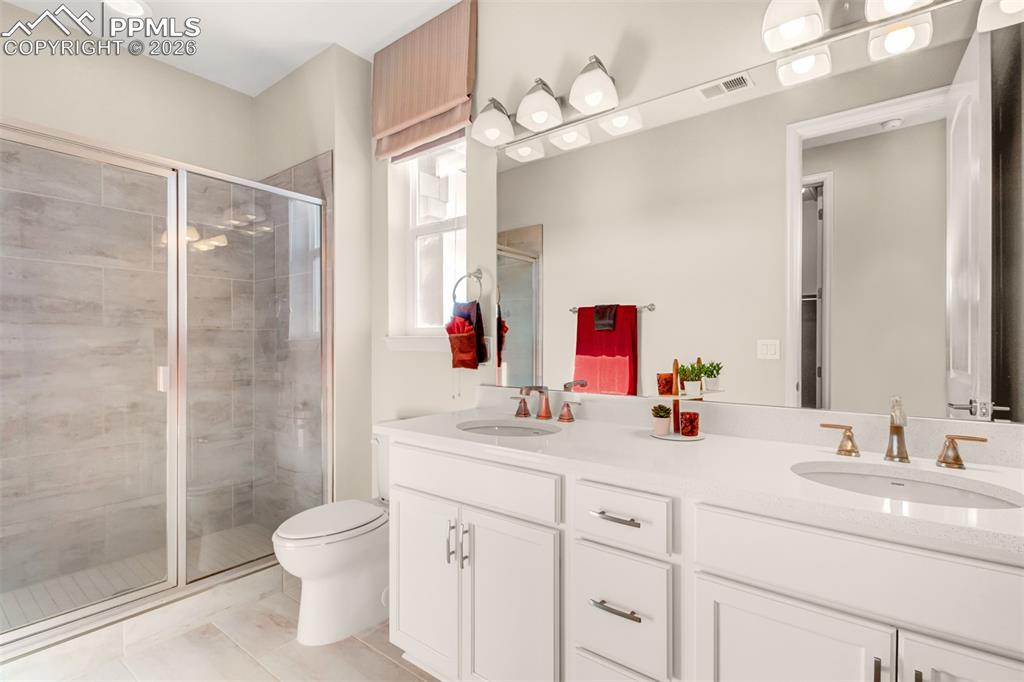 Image 13 of 29: Primary bathroom with dual vanity and free standing shower