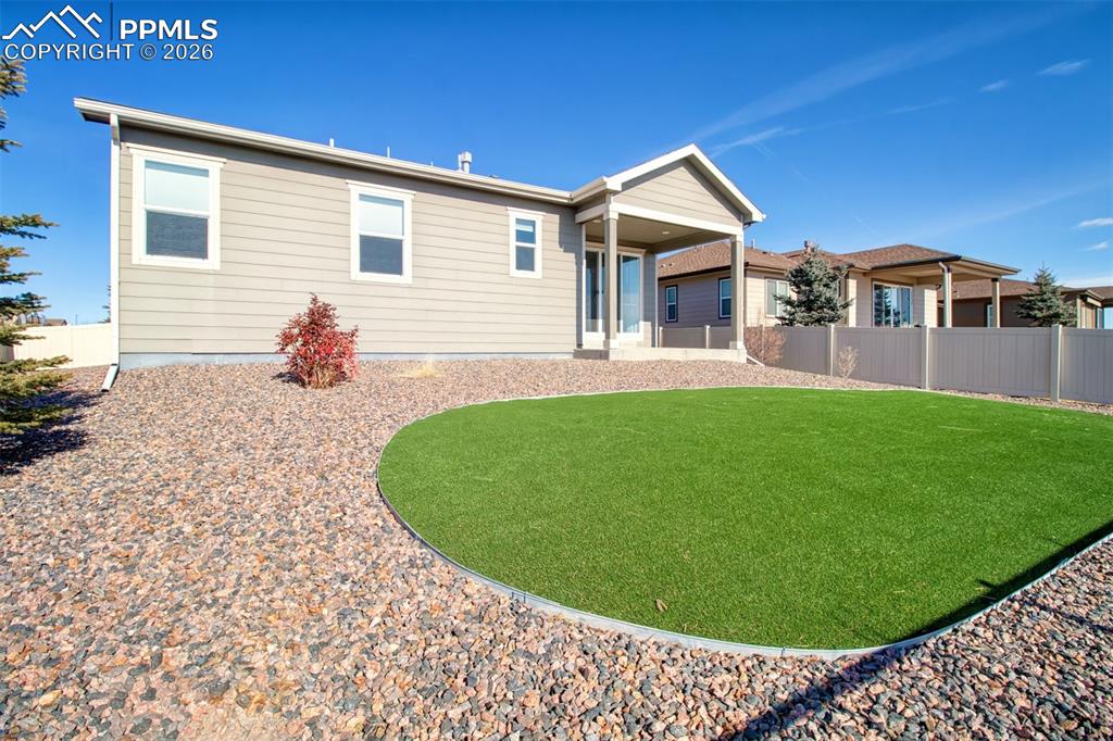 Image 25 of 29: Large backyard with astroturf grass for low maintenance and full enjoyment