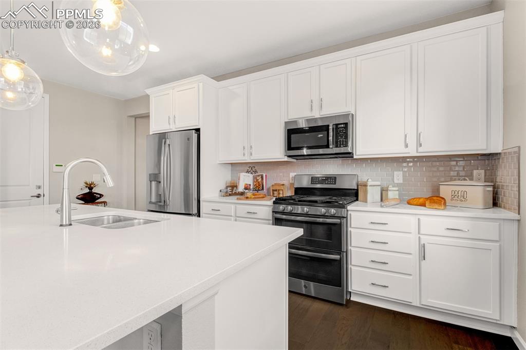 Image 9 of 29: Stainless steel appliances including a gas range