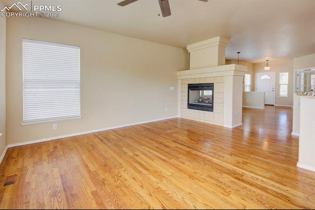Image 16 of 42: Unfurnished living room featuring a tile fireplace, light wood-style floori