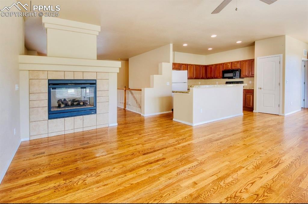 Image 17 of 42: Unfurnished living room with a fireplace, recessed lighting, light wood-sty