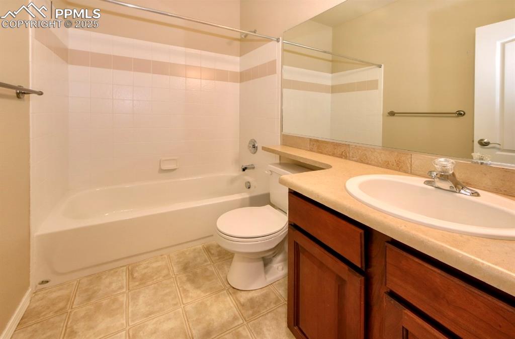 Image 26 of 42: Full bathroom featuring tub / shower combination, vanity, and light tile pa