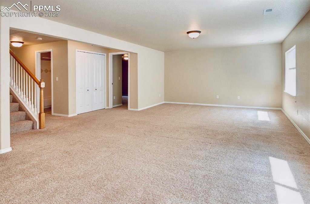 Image 28 of 42: Spare room featuring light carpet and stairway